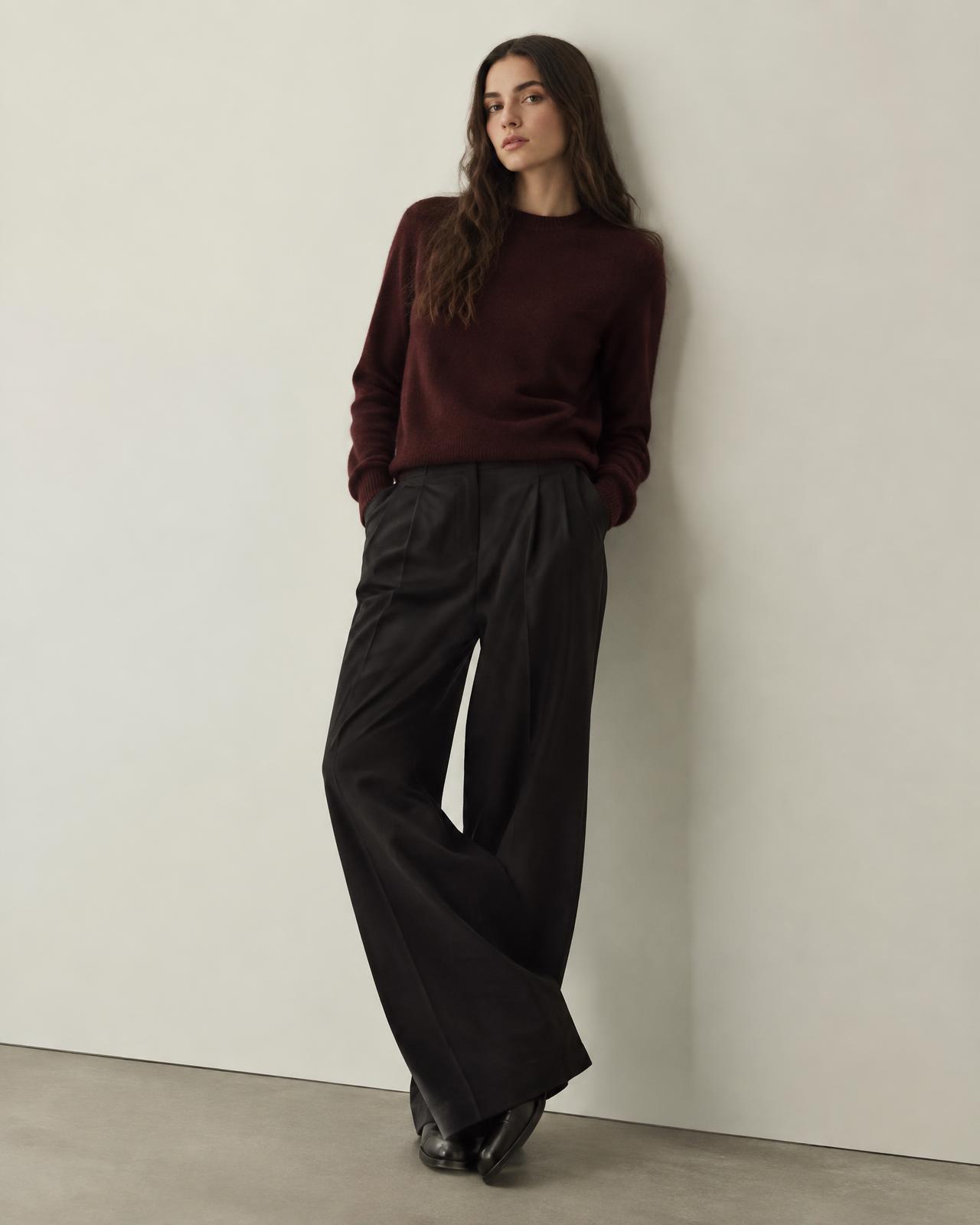 Woman in an oxblood knit and black trousers