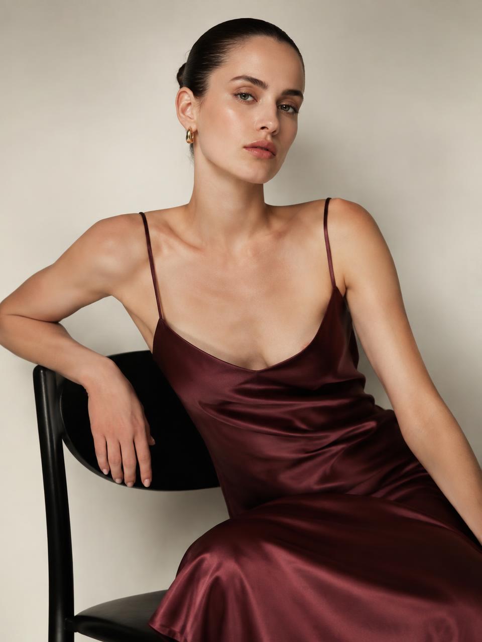 Woman in an oxblood silk slip dress